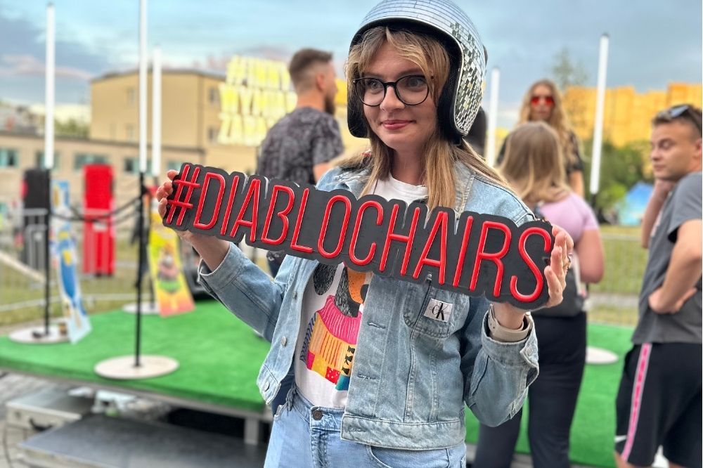 Návštevníčka s rekvizitou Diablo Chairs na Bachanalia 2025