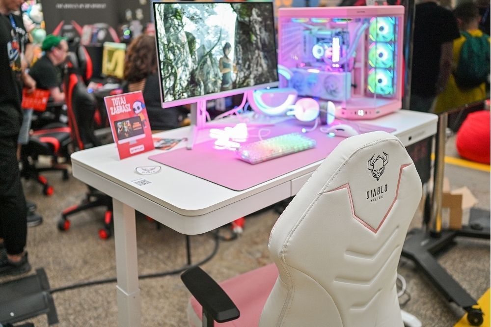 Biela stolička a stôl pri ružovo osvetlenom stanovišti na Pixel Heaven Forward 2025