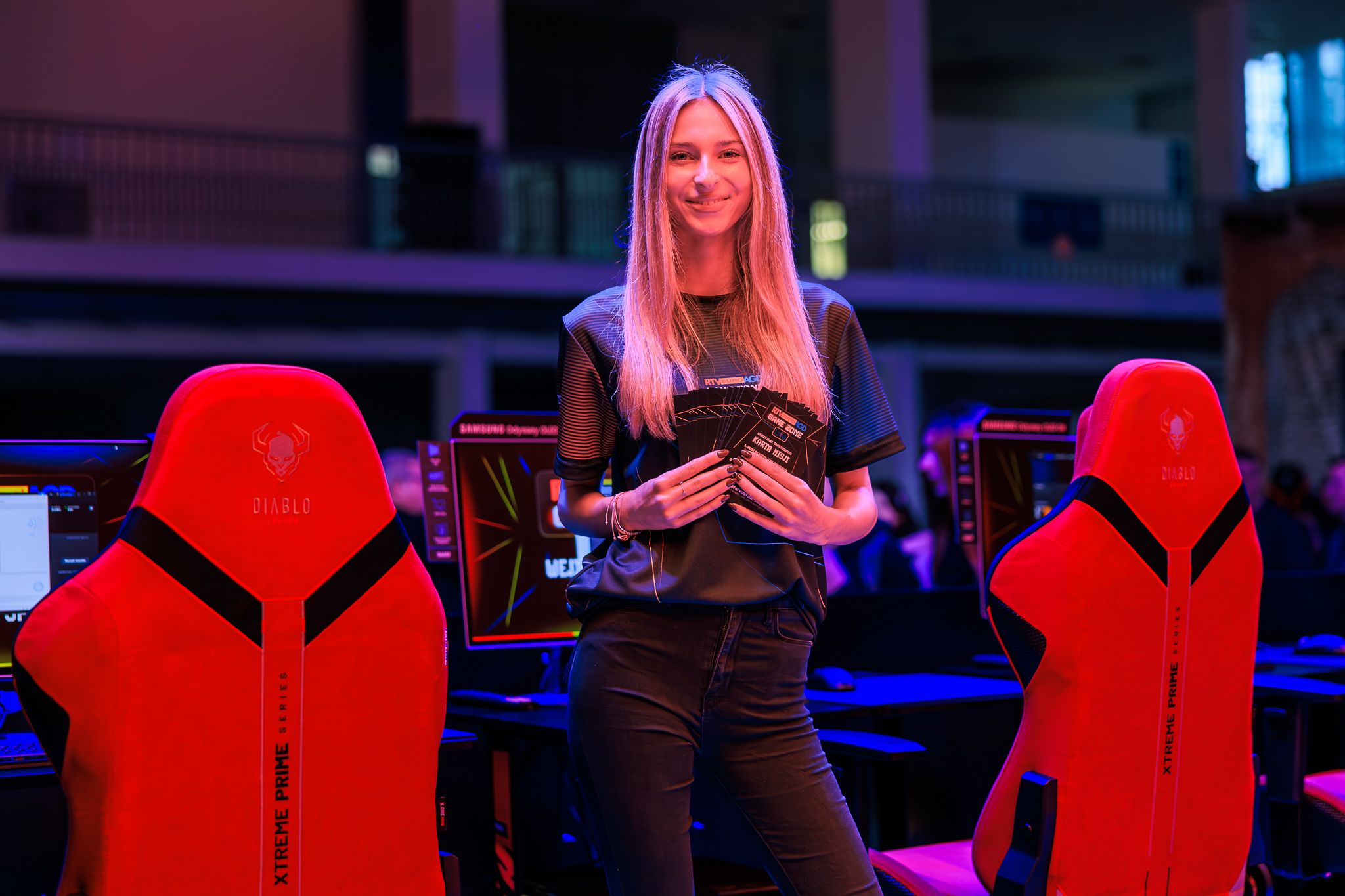 Návštevníčka medzi červenými stoličkami Diablo Chairs v GameZone na PGA