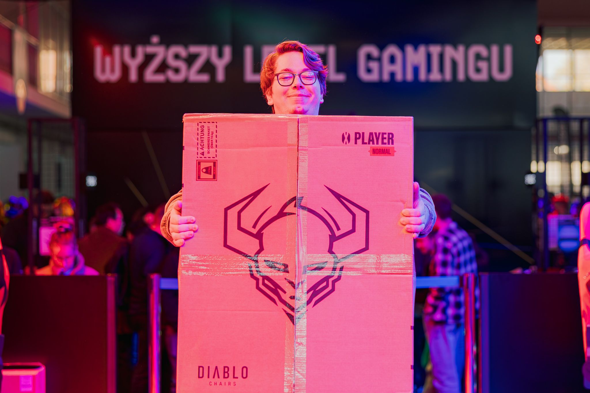 Návštevníčka s krabicou od stoličky Diablo X-Player v GameZone na PGA 2025
