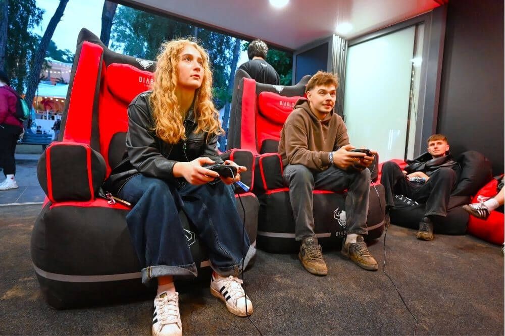 Hráči na stoličkách BAGER s ovládačmi na Rap Stacja 2025